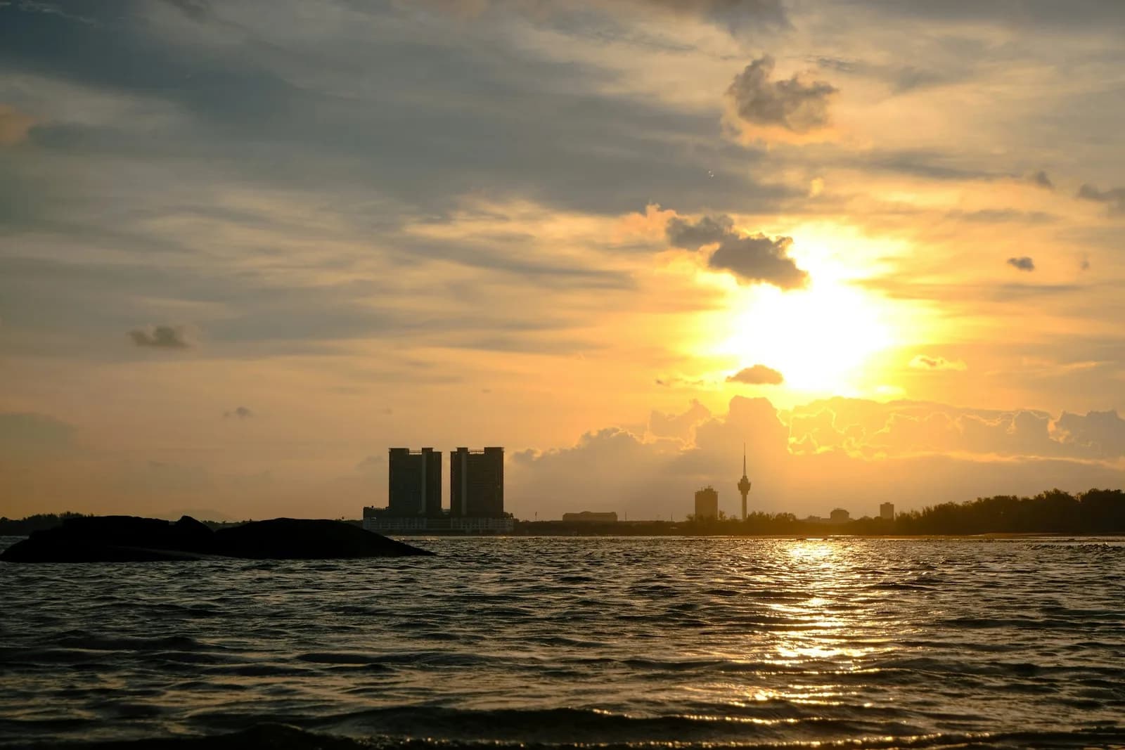 Teluk Cempedak beach at Kuantan with calm sea and a forested cape