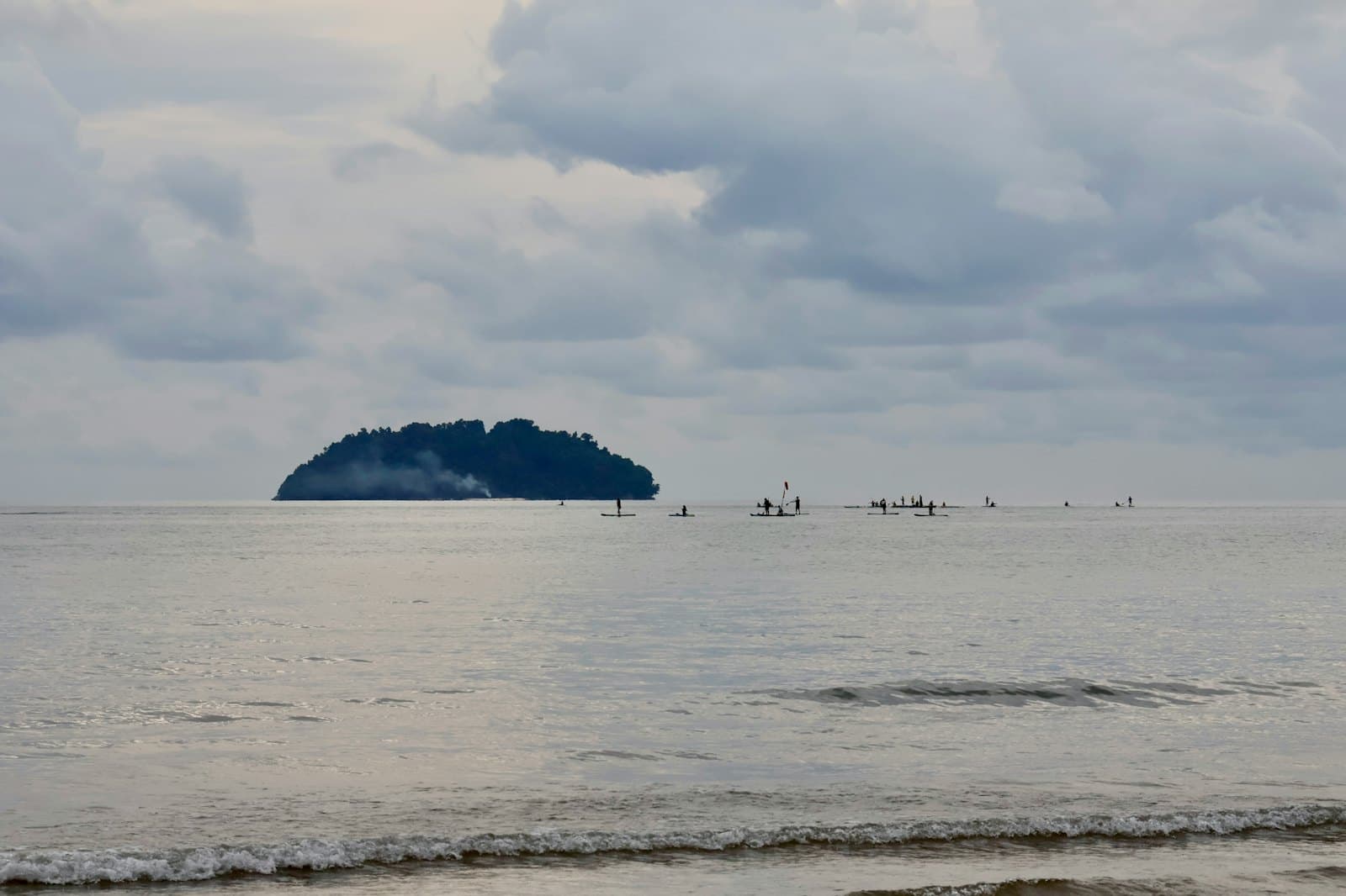 A small boat crossing between two tropical islands