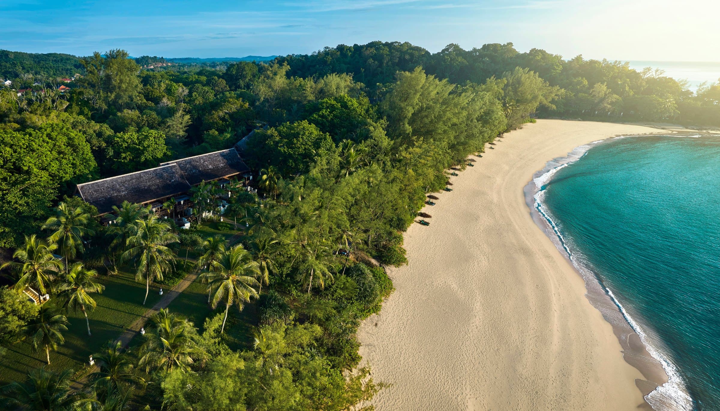 Surf and forested headland on the beach at Tanjong Jara